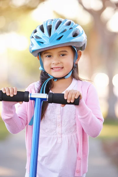 Fille portant un casque de sécurité Scooter d'équitation Images De Stock Libres De Droits