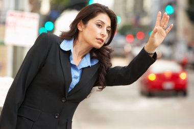 Businesswoman Hailing Taxi In Busy Street clipart
