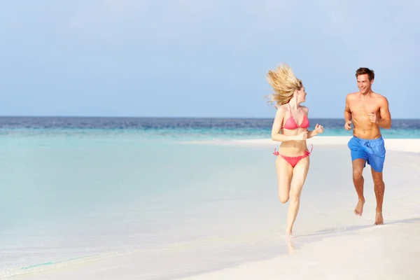 Pareja romántica corriendo en la hermosa playa tropical —  Fotos de Stock