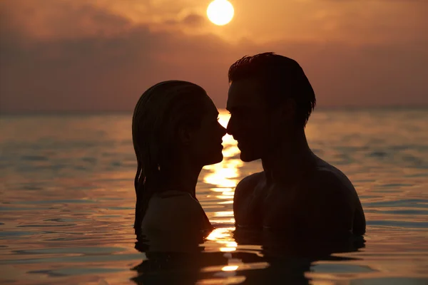 Silhueta de casal romântico em pé no mar — Fotografia de Stock