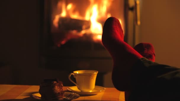 Homem relaxa por fogo quente e contorce os dedos dos pés . — Vídeo de Stock