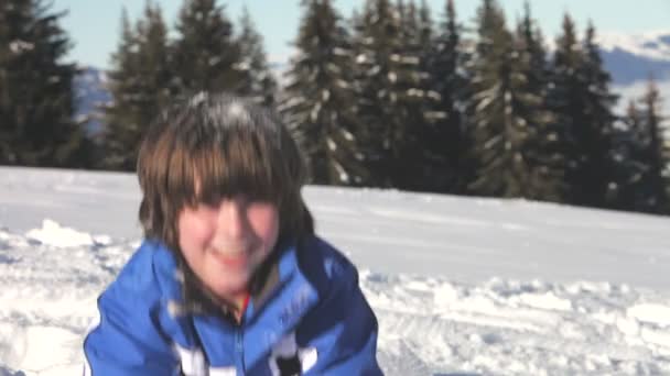 Αγόρι ρίχνει χούφτες χιόνι πάνω από το κεφάλι. — Αρχείο Βίντεο