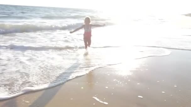 Little girl runs through surf — Stock Video