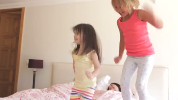 Töchter springen auf das Bett der Eltern — Stockvideo