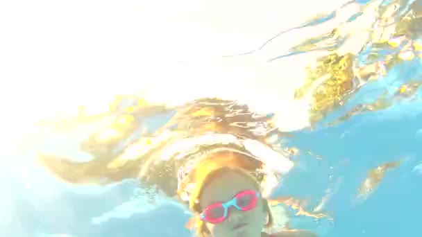 Onderwater weergave jong meisje dragen bril zwemt — Stockvideo