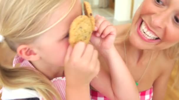 Daughter holds up two cookies over eyes — Stock Video