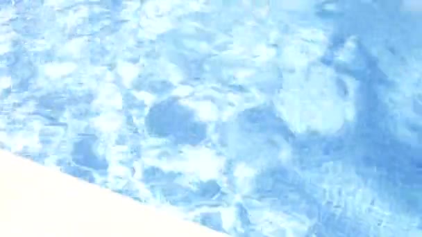 Menina jovem vestindo óculos nada para a borda da piscina — Vídeo de Stock