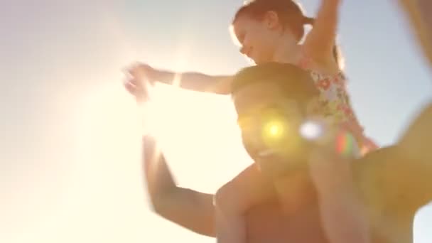 Looking up at daughter as father spins her around on his shoulders. — Stock Video