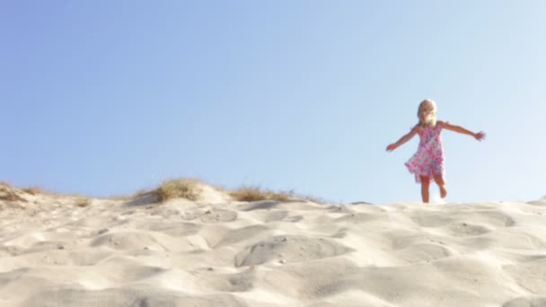 Girl in pretty dress running down sand dune — Stock Video