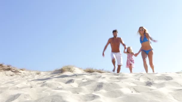 Familie in Badebekleidung läuft Sanddüne hinunter — Stockvideo