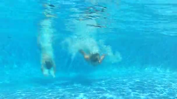 Two boys dive in before switching to underwater viewpoint where he swims towards camera and waves. — Stock Video