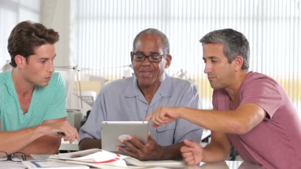 Three men discuss proposal on digital tablet. — Stock Video