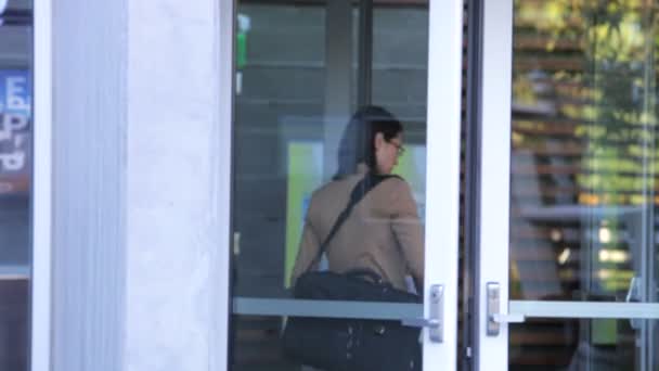 La donna d'affari ridondante che porta la scatola di beni personali spinge la porta aperta di ufficio e parte . — Video Stock