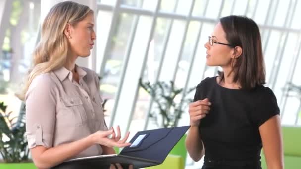Дві бізнес-леді в сучасному офісі обговорюють звіт разом . — стокове відео