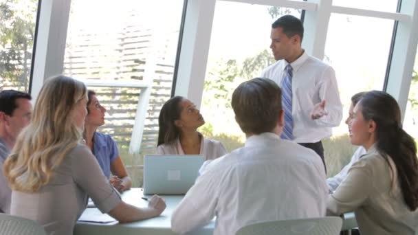 Geschäftsleute sitzen Geschäftsleuten im Stehen gegenüber und sprechen Gruppe an. — Stockvideo
