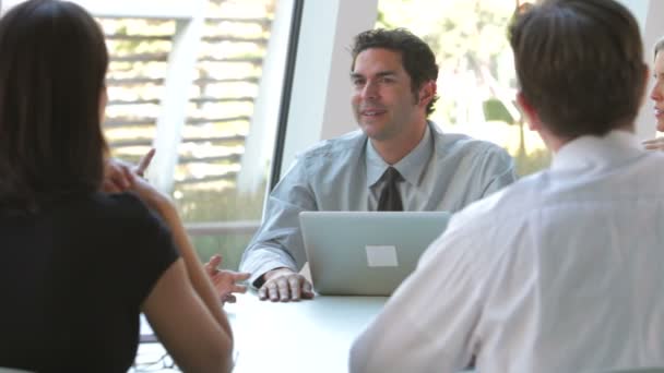 Businesspeople sitting and having an informal meeting looking at data on digital tablet together. — Stock Video