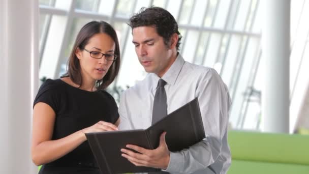 Zakenvrouw en zakenman in moderne kantoor verslag samen bespreken. — Stockvideo
