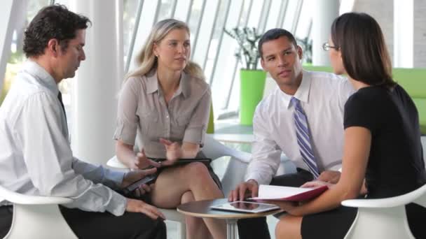 Businesspeople sit and have informal meeting looking at data on digital tablet together. — Stock Video