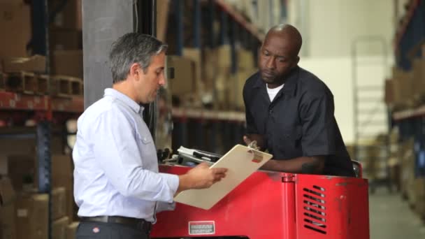 Manger toont fork lift truck stuurprogramma Klembord met document dat zij bespreken. — Stockvideo