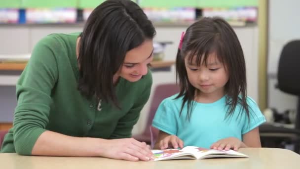 Studente e insegnante che leggono un libro insieme — Video Stock