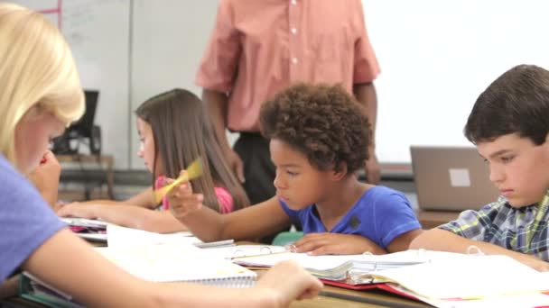 Schüler, der am Schreibtisch arbeitet, hebt die Hand, um Lehrerfrage zu stellen — Stockvideo