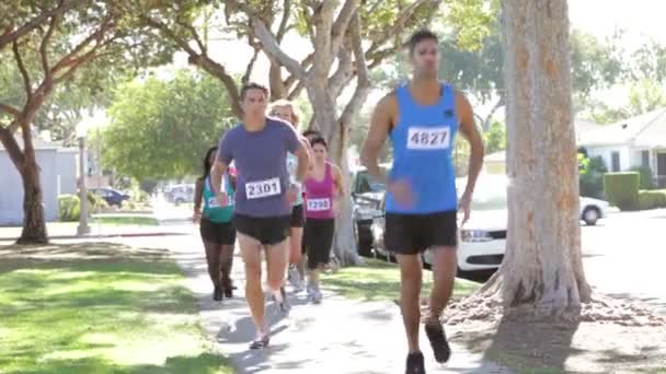 Skupina běžců na předměstské ulici — Stock video