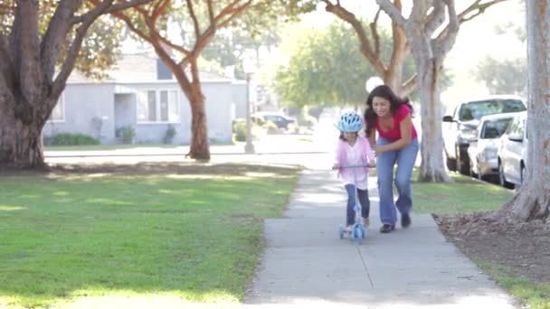 Madre enseñando hija a montar scooter — Vídeo de stock