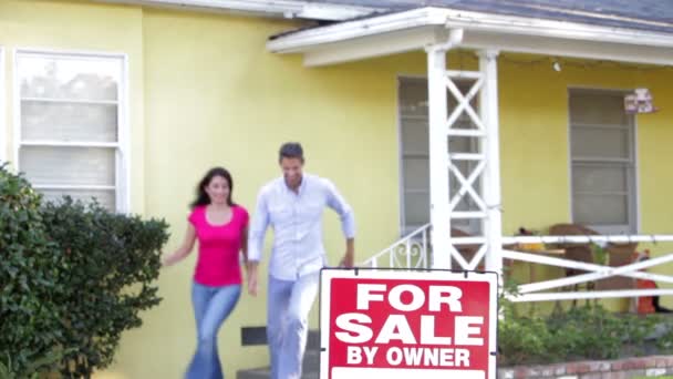 Pareja en espera para la venta signo fuera de casa — Vídeo de stock