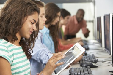 Girl Using Digital Tablet In Computer Class clipart