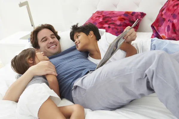 Vater und Kinder entspannen gemeinsam im Bett — Stockfoto