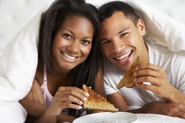 Pareja disfrutando del desayuno en la cama —  Fotos de Stock