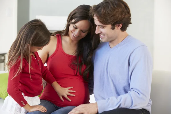 Família com mãe grávida relaxando no sofá juntos — Fotografia de Stock