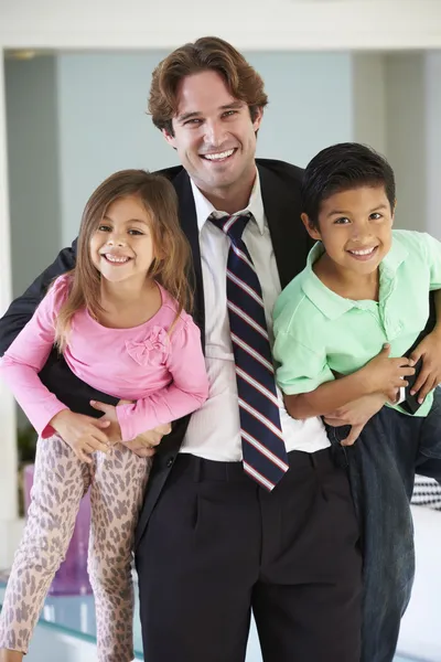 Crianças cumprimentando o pai no retorno do trabalho — Fotografia de Stock