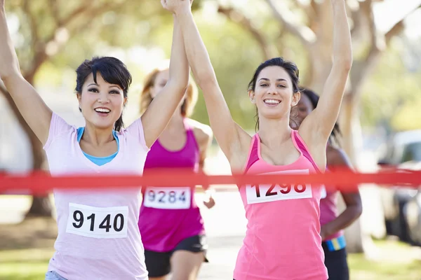 Dos corredores femeninos terminando la carrera juntos — Foto de Stock