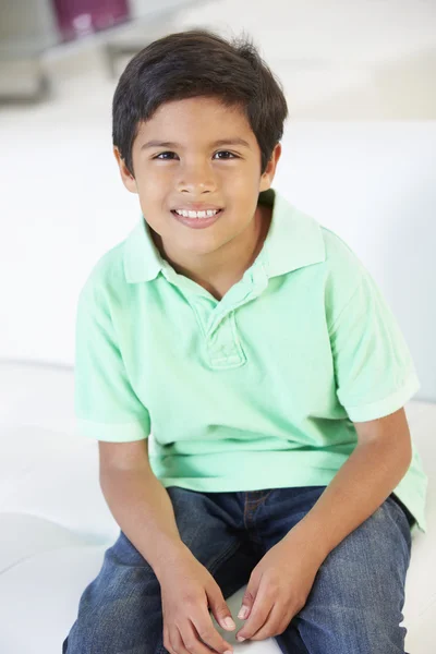 Sorrindo menino sentado no sofá — Fotografia de Stock