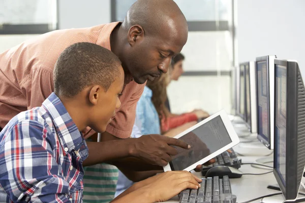 Profesor ayudando a niño a usar la tableta digital en la clase de computadora —  Fotos de Stock