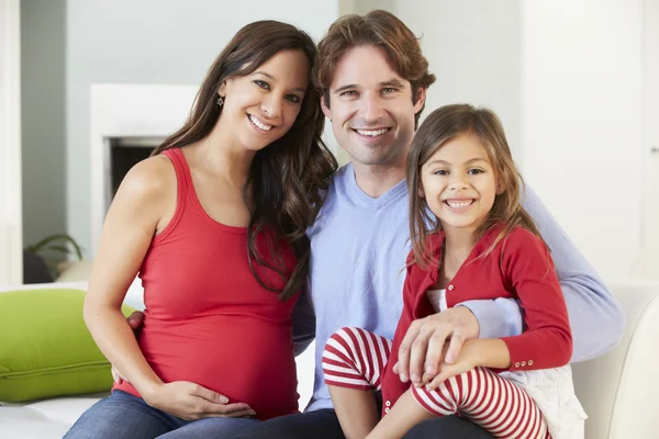 Familia con la madre embarazada relajándose en el sofá juntos — Foto de Stock