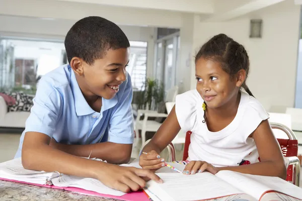 Zwei Kinder machen gemeinsam Hausaufgaben in der Küche — Stockfoto