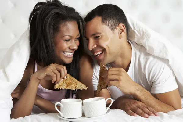 Пара наслаждается завтраком в постели — стоковое фото