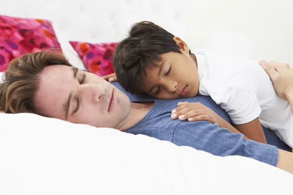 Pai e filho deitados na cama juntos — Fotografia de Stock