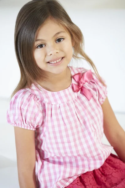 Fille souriante assise sur le canapé — Photo