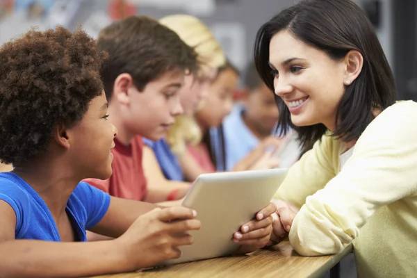 Alumnos en clase usando tableta digital con profesor — Foto de Stock