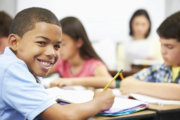 Allievi che studiano alle scrivanie in classe — Foto Stock