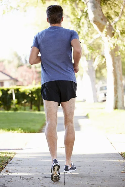Vista trasera del corredor masculino haciendo ejercicio en la calle Suburban — Foto de Stock