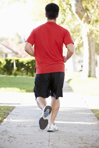 Achteraanzicht van mannelijke atleet uitoefenen op suburban straat — Stockfoto