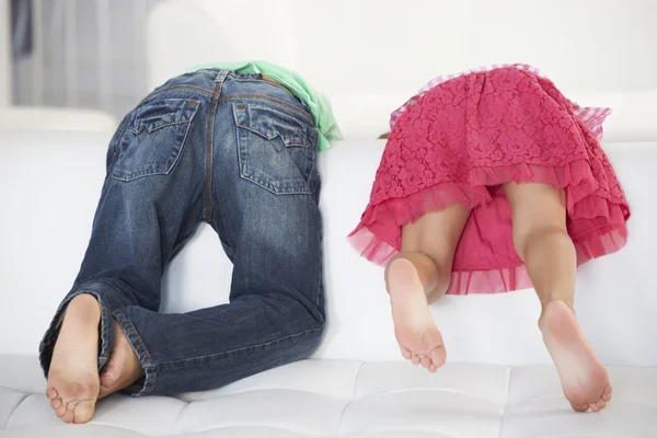 Bakifrån av två barn spelar på soffa — Stockfoto