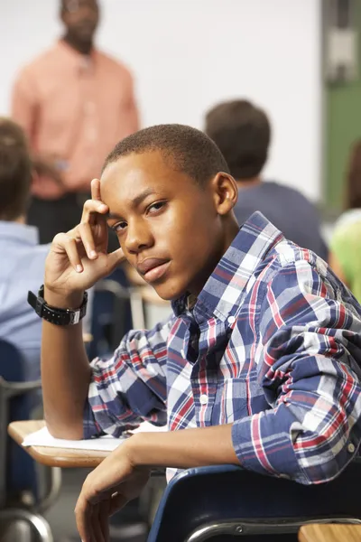 Verveeld mannelijke tiener leerling in de klas — Stockfoto