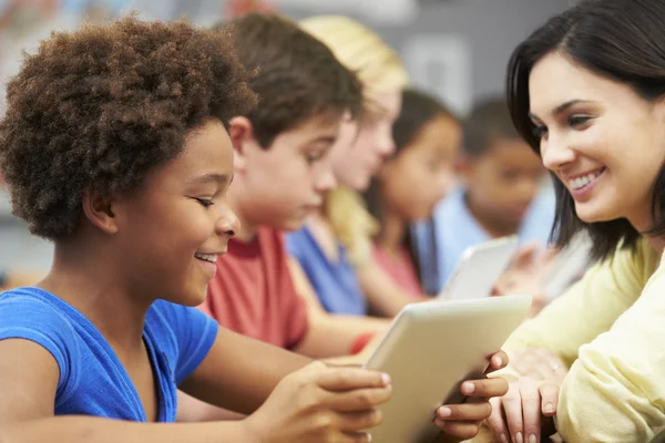 Alunos na classe usando tablet digital com professor — Fotografia de Stock