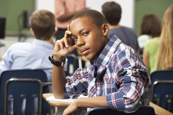 Verveeld mannelijke tiener leerling in de klas — Stockfoto