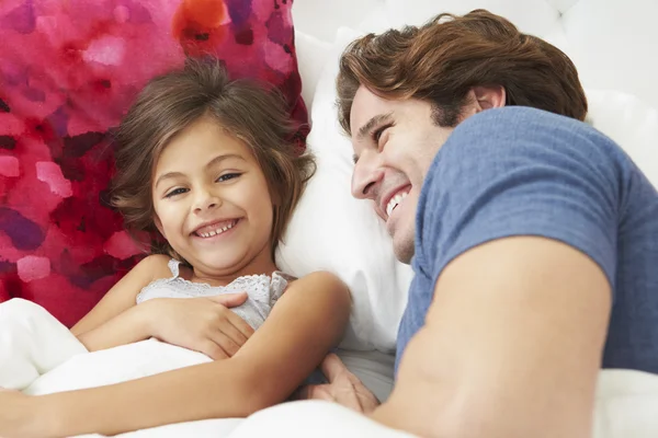 Pai e filha deitados na cama juntos — Fotografia de Stock